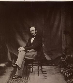 Prince Albert sits in a chair looking at the camera in a Victorian photograph.